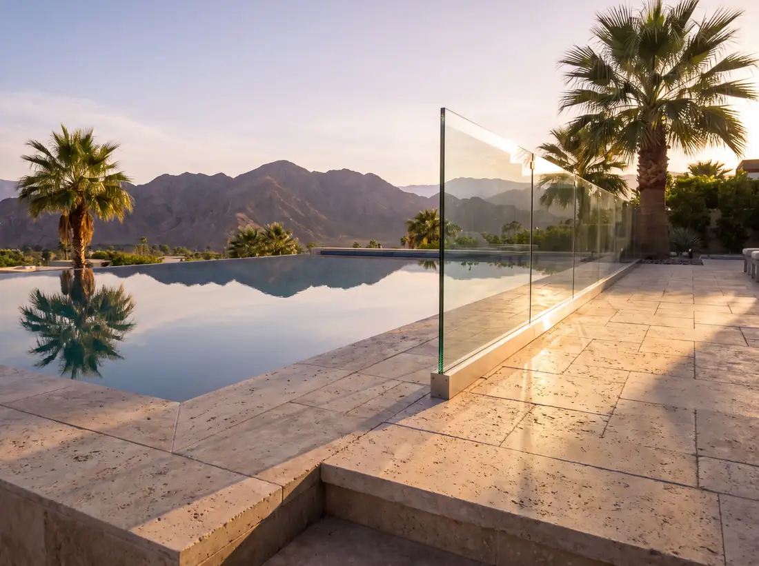 Frameless glass railing at the edge of a raised pool deck