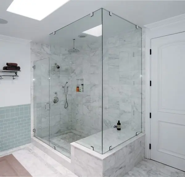 Frameless three panel shower enclosure in a marble bathroom