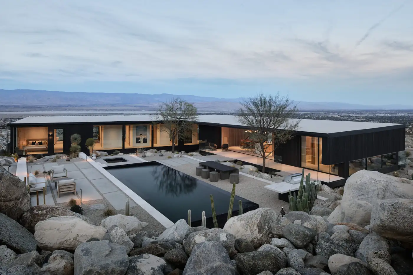 Modern desert residence with full height glazing at dusk