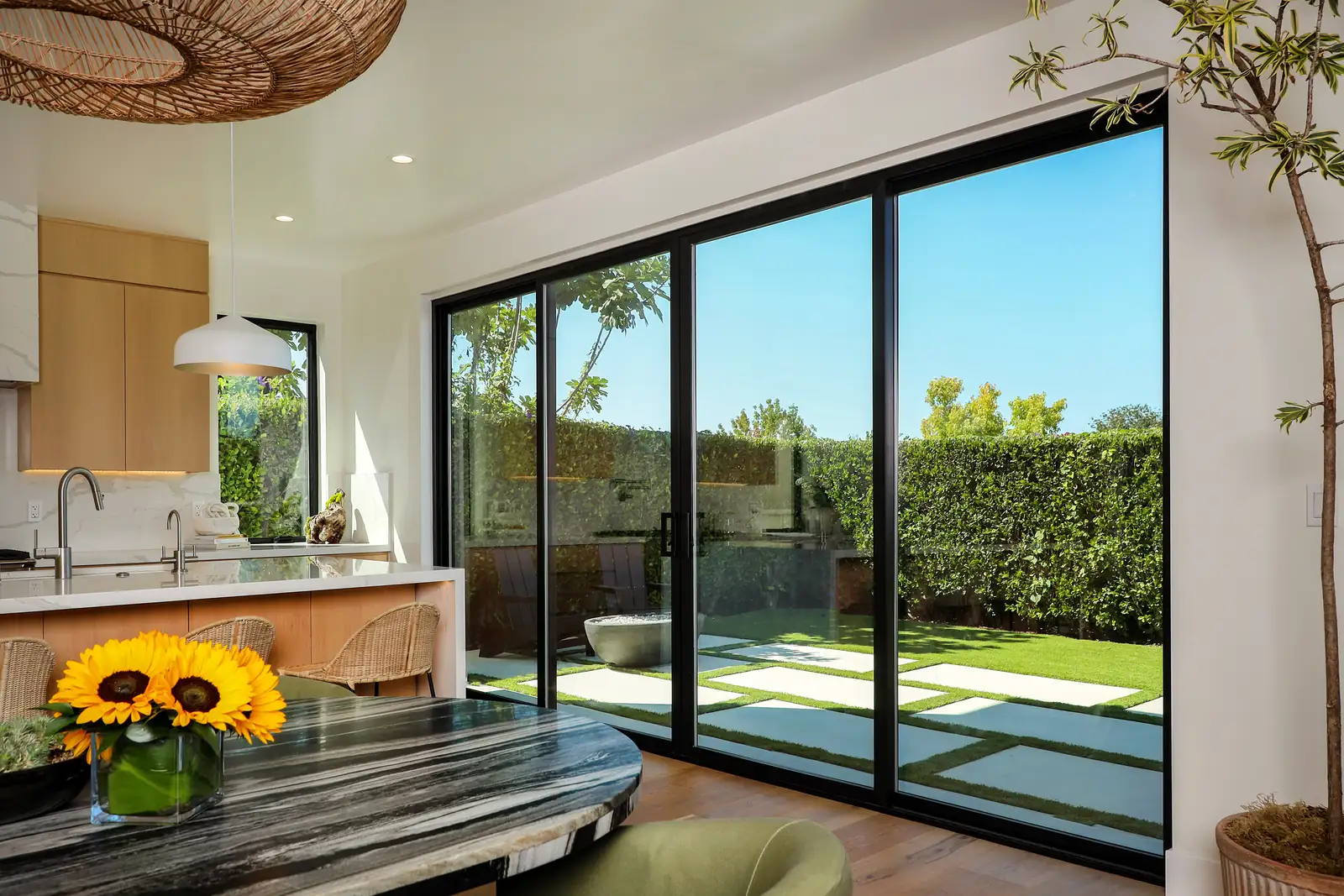 Four panel sliding glass door opening a desert modern home to the garden