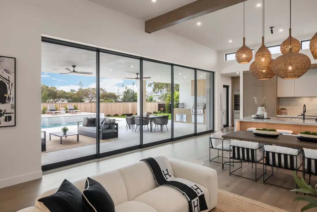 Sliding glass doors opening a great room onto a pool deck